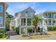 Charming, multi-story beach home featuring a quaint white picket fence, landscaped yard and cross beam railings at 744 Gate Post Dr, Mount Pleasant, SC 29464