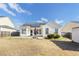 View of a house with solar panels, a concrete patio, and a green lawn, providing an inviting outdoor living space at 7649 Fayetteville Rd, North Charleston, SC 29418