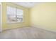 Bright bedroom featuring a large window, neutral carpet, and ceiling fan at 7649 Fayetteville Rd, North Charleston, SC 29418