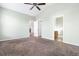 Light-filled bedroom with ceiling fan, neutral walls, carpeted floor, and doorways to other rooms at 7649 Fayetteville Rd, North Charleston, SC 29418