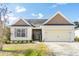 Inviting single-story home with a two-car garage, manicured landscaping, and appealing architectural details at 7649 Fayetteville Rd, North Charleston, SC 29418