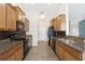 An open kitchen offers granite countertops, wood cabinets and black appliances at 7649 Fayetteville Rd, North Charleston, SC 29418