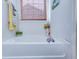 A relaxing bathtub featuring woven window blind, decorative plants, and silver faucet at 7720 Kinston St, North Charleston, SC 29418