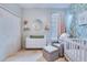 Well-decorated Bedroom with crib, chair, round mirror, and leafy patterned wallpaper at 7720 Kinston St, North Charleston, SC 29418