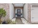 Inviting front entrance with decorated door, lush landscaping, and adjacent garage entry at 7720 Kinston St, North Charleston, SC 29418