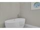Bright bathroom featuring a modern soaking tub, a round window, and marble floors at 8704 Middleton Point Ln, Edisto Island, SC 29438
