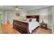 Spacious bedroom with a sleigh bed, complemented by hardwood floors and a cozy seating area at 8704 Middleton Point Ln, Edisto Island, SC 29438