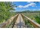 Picturesque wooden walkway leading to a private dock, offering tranquil waterfront views at 8704 Middleton Point Ln, Edisto Island, SC 29438