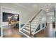 Hallway with staircase leading to a dining room with dark blue accent wall and wood floors at 8704 Middleton Point Ln, Edisto Island, SC 29438