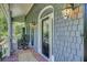 Charming front porch with rocking chairs, brick flooring and arched door at 8704 Middleton Point Ln, Edisto Island, SC 29438