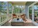 Covered porch featuring brick flooring, wicker chairs, and a glass-topped table for outdoor relaxation at 8704 Middleton Point Ln, Edisto Island, SC 29438