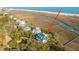 Areal view of a waterfront property featuring lush greenery, private dock, and stunning ocean views from the white sand beach at 944 Hammocks Way, Edisto Island, SC 29438