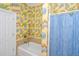 Bathroom with shower, and bathtub, decorated with bright floral wallpaper at 944 Hammocks Way, Edisto Island, SC 29438