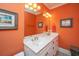 Bright bathroom features double sinks with gold fixtures, white cabinetry, and colorful wall decor at 944 Hammocks Way, Edisto Island, SC 29438