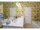 Elegant bathroom with double vanity, tub, and bright floral wallpaper at 944 Hammocks Way, Edisto Island, SC 29438