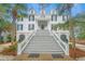 Stately two-story home with a grand entrance surrounded by mature trees and lush landscaping at 944 Hammocks Way, Edisto Island, SC 29438