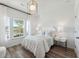 Bright bedroom with hardwood floors, white walls, white bedding, and a modern light fixture at 1008 Tulip Shell St, Summerville, SC 29485