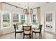 Bright dining area features a modern chandelier, stylish table, and natural light from surrounding windows at 1014 Tulip Shell St, Summerville, SC 29485