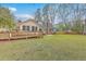 A large backyard with green grass, a wooden deck with handicap access, and mature trees at 103 Laurens Ct, Summerville, SC 29485