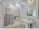 Well-lit bathroom with shower and pedestal sink featuring tan tile floors and gray rug at 103 Laurens Ct, Summerville, SC 29485