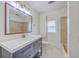 Bright bathroom features a blue vanity, white countertop, modern fixtures, and a large, framed mirror at 103 Laurens Ct, Summerville, SC 29485