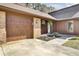 Inviting front entrance with brick accents, lush greenery, and a wooden garage door at 107 Four Iron Dr, Summerville, SC 29483