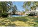 A backyard featuring a refreshing pool, a well-manicured lawn, and lush, mature trees offering shade and privacy at 107 President Cir, Summerville, SC 29483