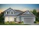 Charming two-story home with blue siding, well-manicured lawn, and a two-car garage at 118 Royal Cainhoy Way, Huger, SC 29450