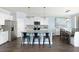 Modern kitchen featuring white cabinets, stainless steel appliances, and a granite countertop island with bar stools at 118 Royal Cainhoy Way, Huger, SC 29450