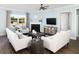 Cozy living room with a fireplace, comfortable seating, and natural light from large windows at 118 Royal Cainhoy Way, Huger, SC 29450
