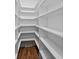 White walk-in pantry featuring organized shelves and hardwood floors at 1308 Coleridge St, Charleston, SC 29407