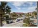 Elevated view of parking area, canal, and multistory condos with palm trees and greenery on a bright sunny day at 134 Marsh View Villas, Folly Beach, SC 29439