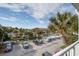 Overhead view of condos featuring a parking area, boats on a canal, palm trees, and landscaping on a sunny day at 134 Marsh View Villas, Folly Beach, SC 29439