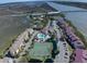 Aerial view of condos featuring a pool, tennis courts, and waterway access with boat docks at 134 Marsh View Villas, Folly Beach, SC 29439