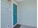 A teal door with the number 134, an entrance mat, and light green siding provides a homey aesthetic at 134 Marsh View Villas, Folly Beach, SC 29439