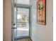 Open doorway with view to patio, featuring metal railings and tropical plants, with 