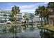 An exterior view of multi-level condo building with boat parking, dock, and grassy area adjacent to a body of water at 134 Marsh View Villas, Folly Beach, SC 29439