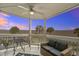 This covered patio features a seating area with views of tropical trees and marshy landscape at sunset at 134 Marsh View Villas, Folly Beach, SC 29439