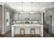 Modern kitchen boasts a large island, stainless steel appliances, gray cabinets, and stylish pendant lighting at 138 Maritime Way, Summerville, SC 29485