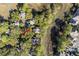 Overhead shot of marsh-front homes in a green, wooded neighborhood, with an arrow on the property at 1409 Dune Loft Villas, Seabrook Island, SC 29455