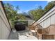 A balcony with a covered grill, rattan chairs, and views of the surrounding trees at 1409 Dune Loft Villas, Seabrook Island, SC 29455