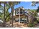 An exterior elevation of a stilted house with wood siding and a screened-in porch at 1409 Dune Loft Villas, Seabrook Island, SC 29455
