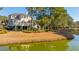 A scenic backyard view with palm trees, a well-maintained lawn, and waterfront access at 1427 Shell Fish Ct, Mount Pleasant, SC 29466