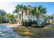 Inviting two story traditional home with manicured lawn, palm trees, and a circular driveway at 1427 Shell Fish Ct, Mount Pleasant, SC 29466
