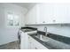Functional laundry room features granite counters, ample cabinet storage, sink, and a front-load washer and dryer at 1427 Shell Fish Ct, Mount Pleasant, SC 29466
