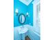 Stylish powder room featuring blue walls, beadboard wainscoting, and decorative sconces and mirror at 1427 Shell Fish Ct, Mount Pleasant, SC 29466