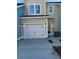 Exterior view of a townhome garage with carriage doors, exterior lights, and driveway at 143 Cantona Dr, Summerville, SC 29483