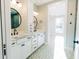 Bright bathroom featuring a double vanity, decorative floor tiles, and round mirrors at 143 Harvest Way, Walterboro, SC 29488