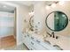 Well-lit bathroom boasts a dual sink vanity, marbled countertops, round mirrors and unique geometric floor tiles at 143 Harvest Way, Walterboro, SC 29488