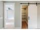 This bedroom features hardwood floors, an open doorway, and a barn door leading to a closet at 143 Harvest Way, Walterboro, SC 29488